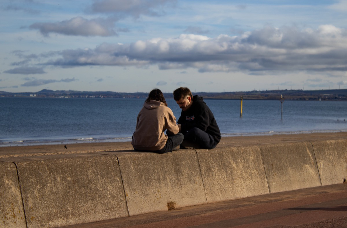 Street photo of a pair of people at Portobello beach